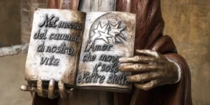 Dettaglio del libro della statua di dante alighieri che reca il primo e l'ultimo verso della Divina Commedia